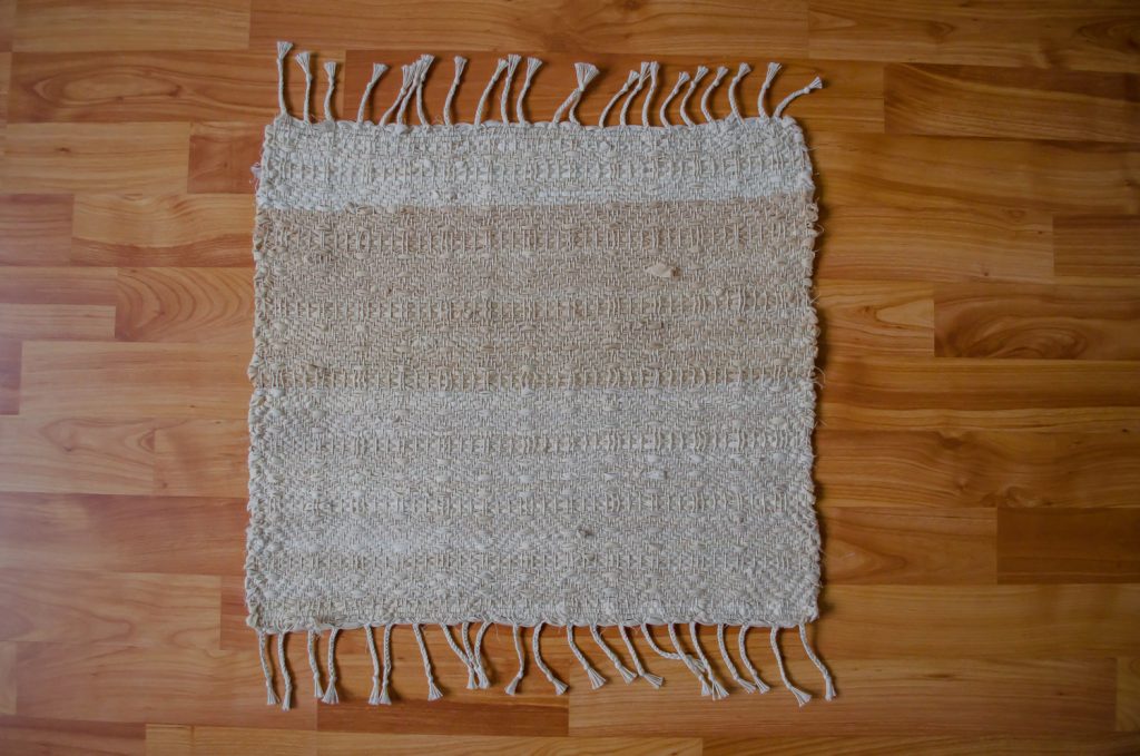 Upcycle textiel, handgeweven uniek vloerkleed van een oud hoeslaken, geverfd met uienschillen.