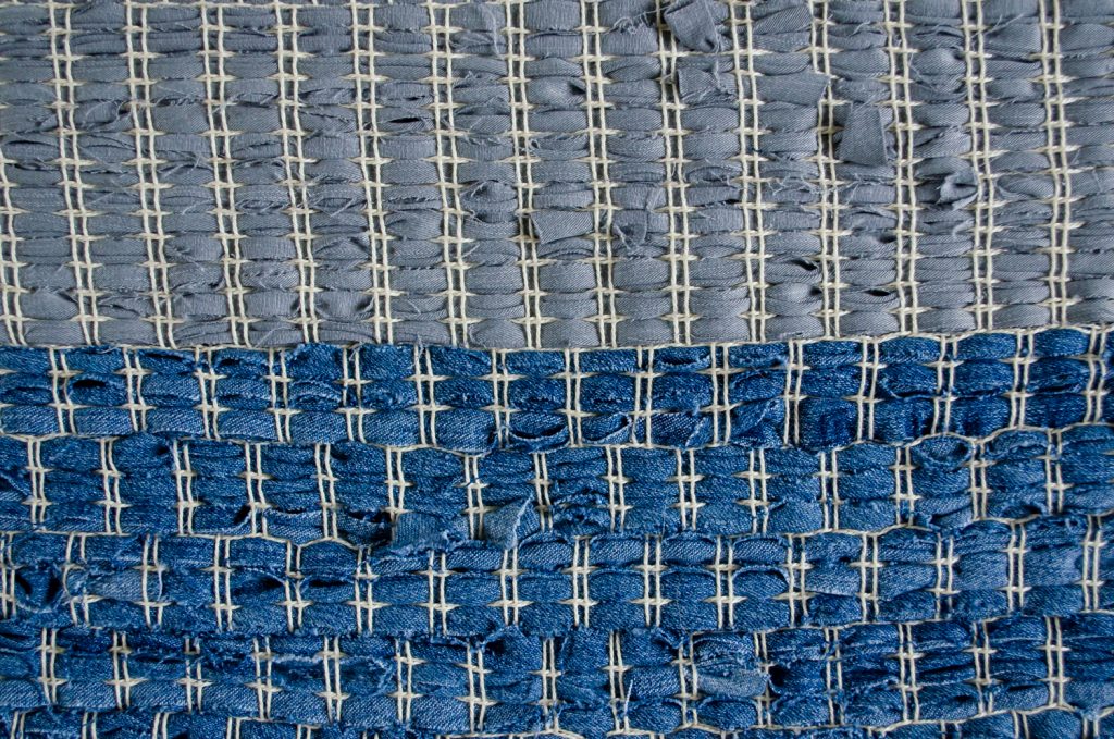 Upcycle textiel, handgeweven uniek vloerkleed van oude spijkerbroeken, detail.