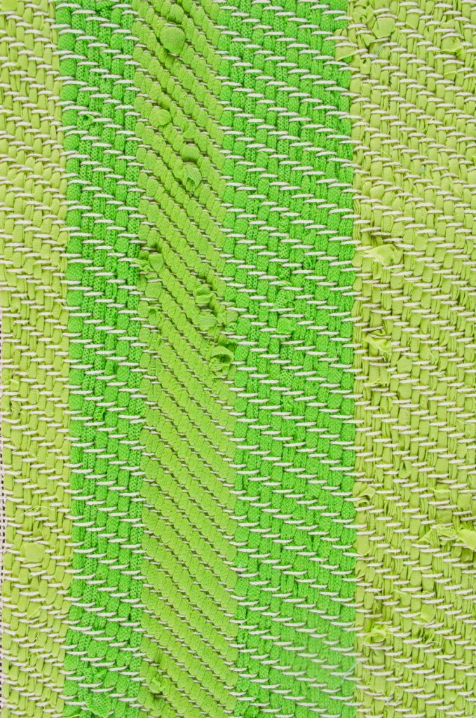 Detail van een van de herinneringskleden, waarop goed te zien is hoe verschillende textielsoorten reageren op de keperbinding.